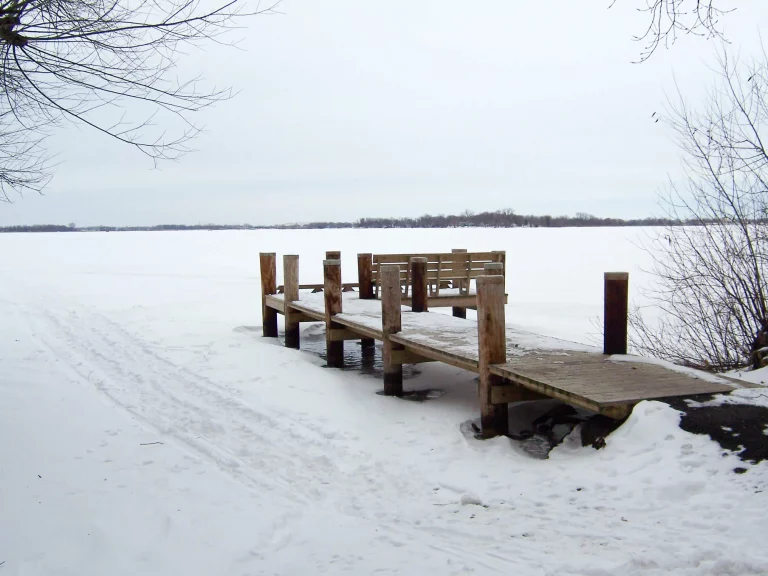 Frozen lake covered in snow with dock