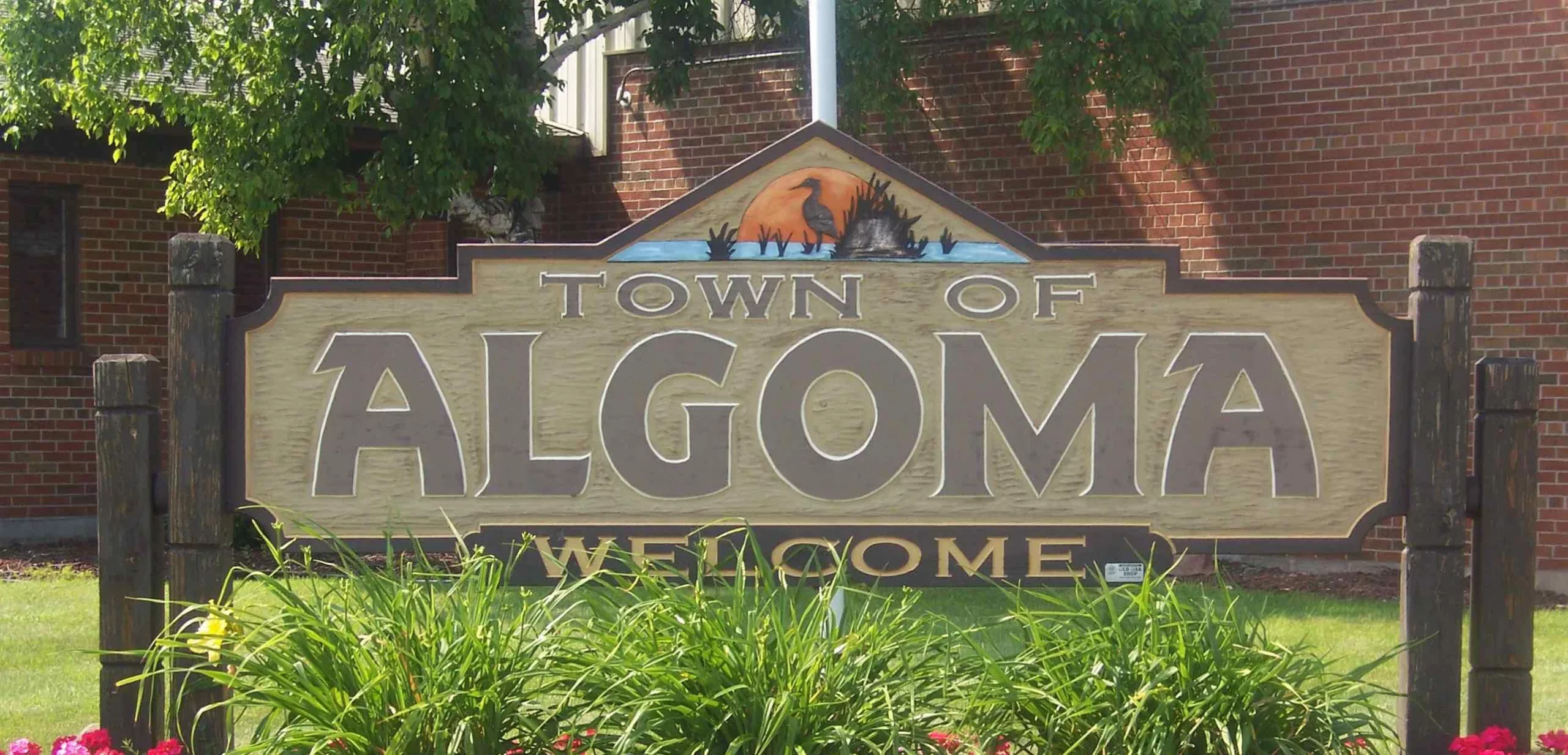 Town of Algoma welcome sign with building in background