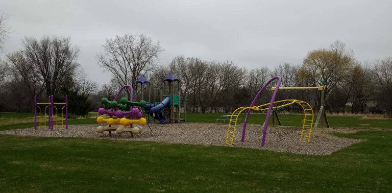 Kewaunee Park playground surrounded by grass and trees
