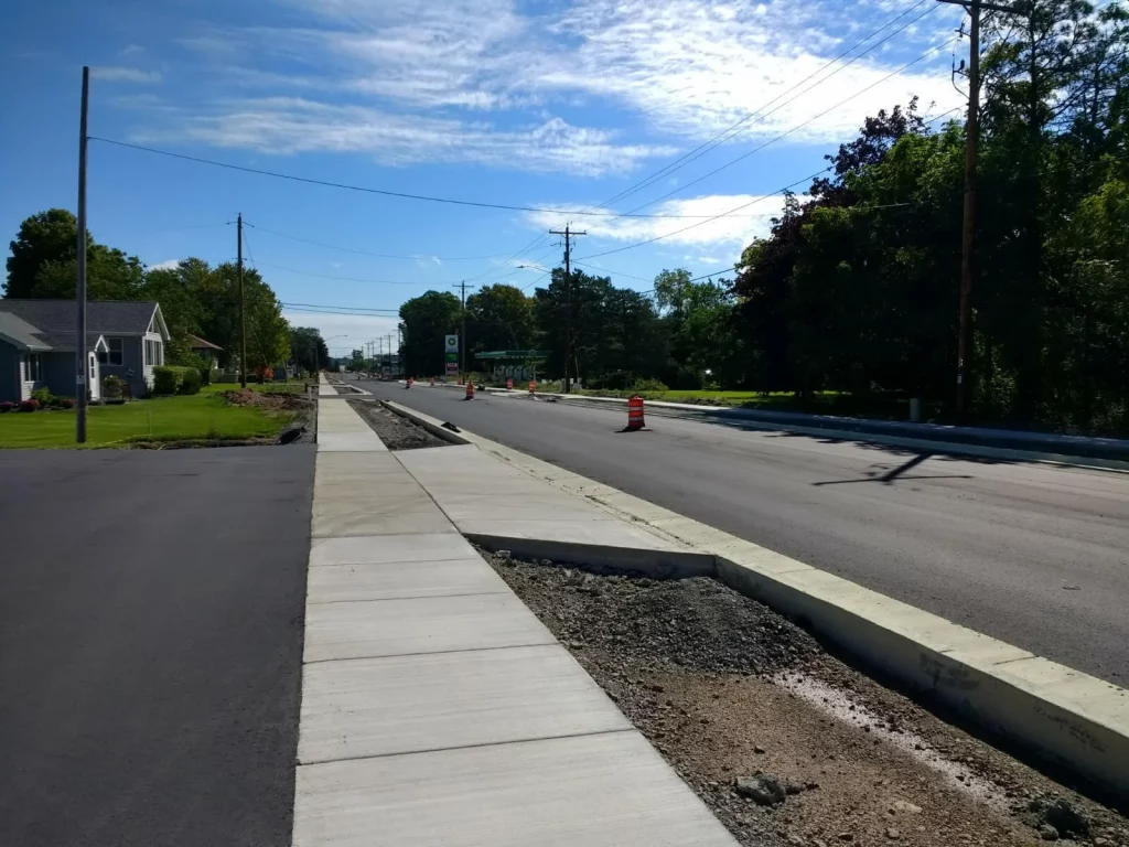 A newly constructed sidewalk next to a residential street